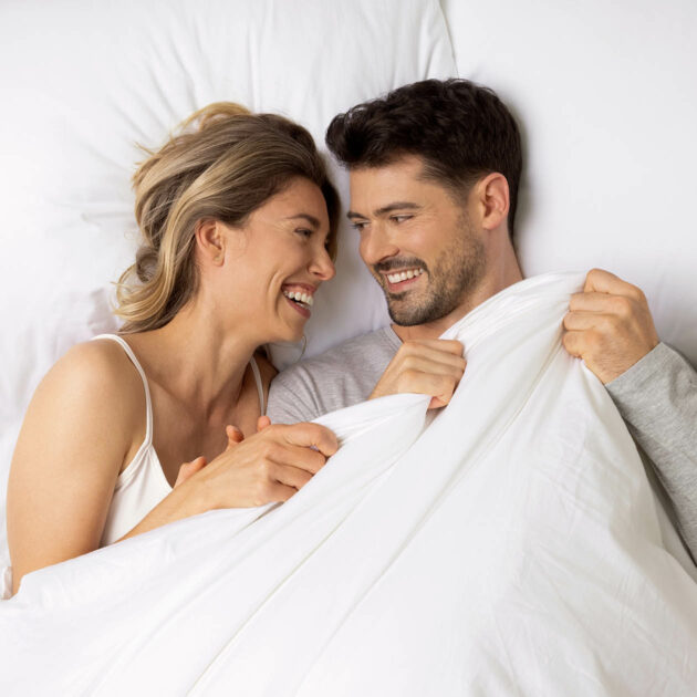 Bild aus dem Fotoshooting auf dem eine Frau und ein Mann im Bett liegen