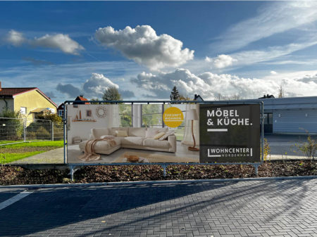 Bild von einem Banner auf dem Parkplatz mit einem Bild von einem Sofa und der Aufschrift 