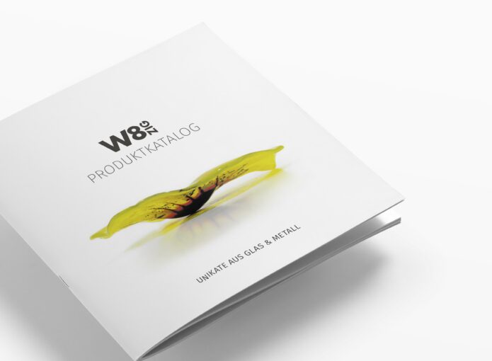 Das Designkonzept spiegelt sich auch in dem Katalog wieder: Zu sehen ist die Frontseite des W8zig Katalogs. Darauf sieht man eine gelbe Glasblume und das W8zig Logo.