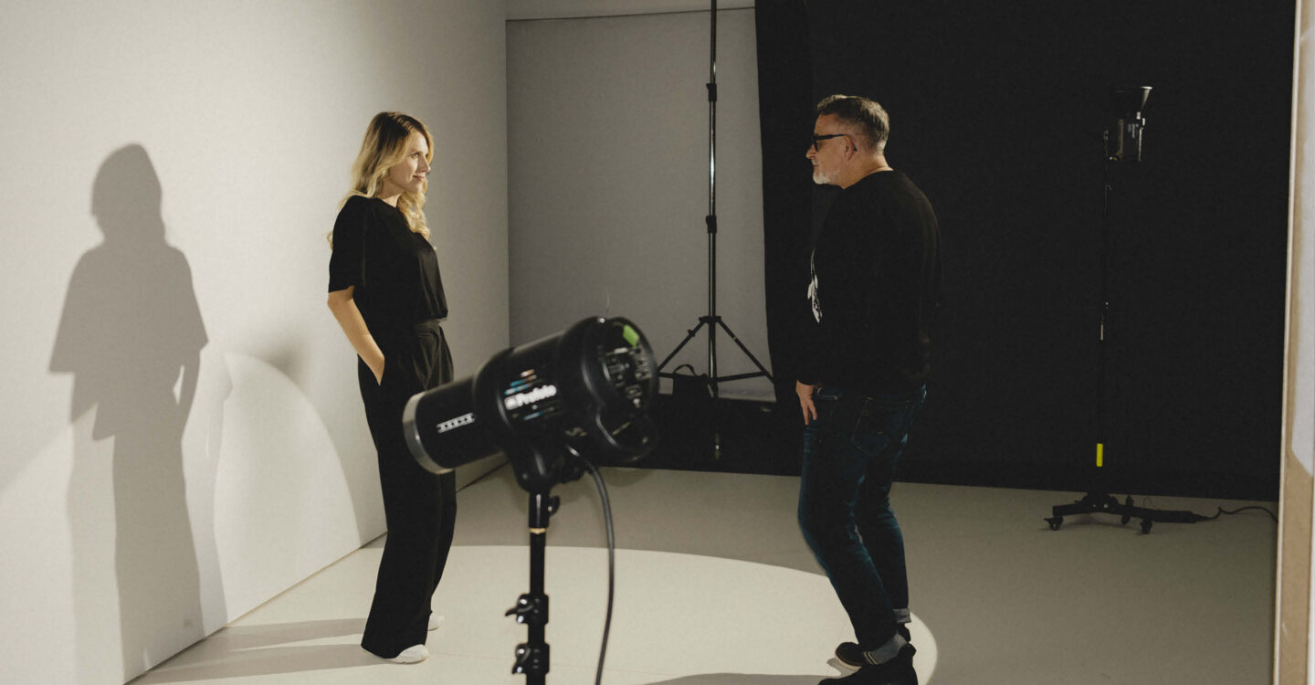 Fotoshooting im Studio mit Model und Fotograf vor Lichtsetup zeigt professionelle Portraitfotografie und kreative Inszenierung
