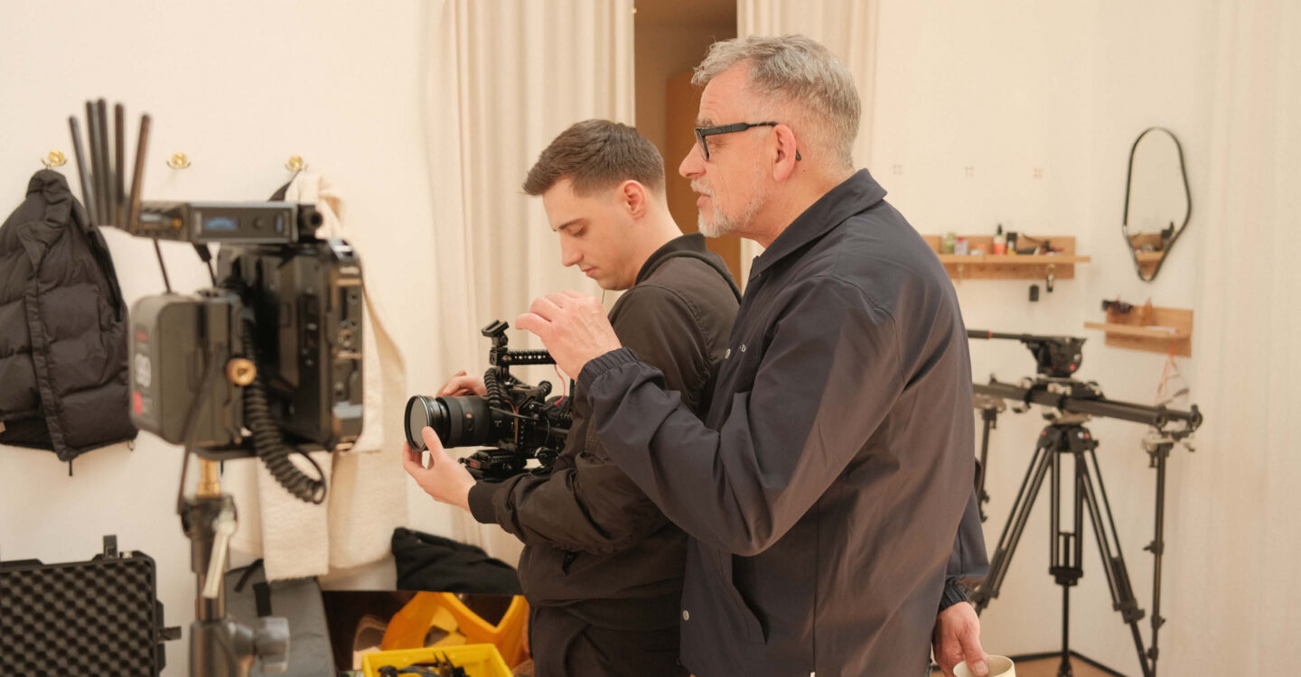 Zwei Personen arbeiten gemeinsam an Kamera im Studio und prüfen Einstellungen während eines professionellen Fotoshootings