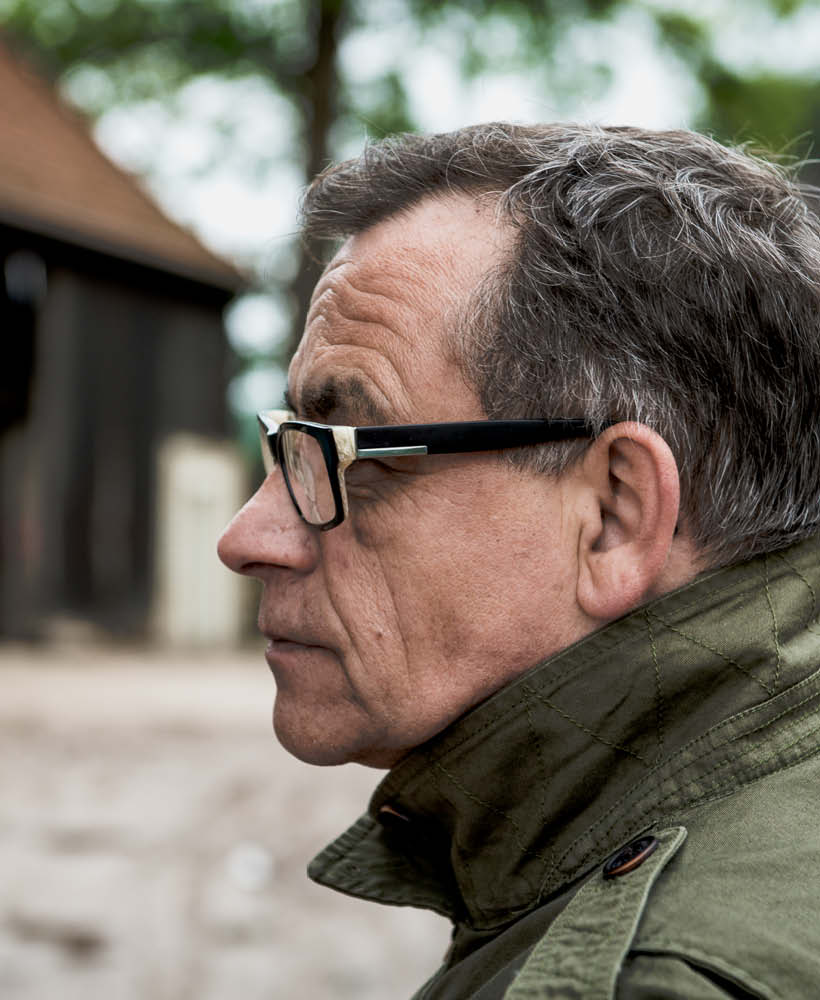 30 Jahre schirmers Geschichte. Seitenprofil von Christian Schirmers, der Gründer von schirmers. agentur. Er trägt eine grüne Jacke mit hochgestelltem Kragen, aufgenommen von dem neuen Agentursgebäude
