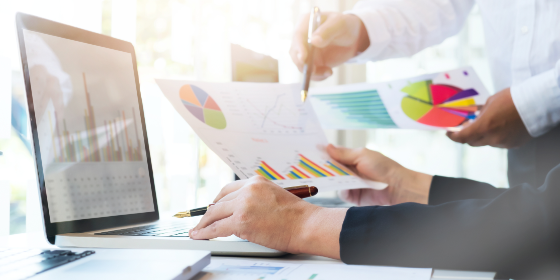 Geschäftsleute analysieren gemeinsam Diagramme, Kennzahlen und Auswertungen am Laptop – datenbasierte Analyse, Strategie und Unternehmensplanung.